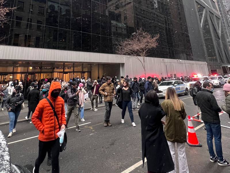 A crowd gathers outside at the Museum of Modern Art in New York after a man stabbed two employees AP