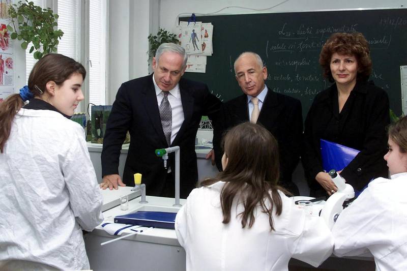 Israeli finance minister Benjamin Netanyahu (2nd L) ,executive vice-president of Ronald S. Lauder foundation George Ban (background C) and Tova Ben Nun (background R) , the director of Lauder-Reut school, visits the biology lab of the Lauder-Reut school in Bucharest 18 December 2003. Netanyahu  laid the foundation stone of the Lauder-Reut high school building.Israeli finance minister is in a five days visit in Romania for strengthening economical and finance relations between the two countries. AFP PHOTO STRINGER (Photo by STRINGER / AFP)