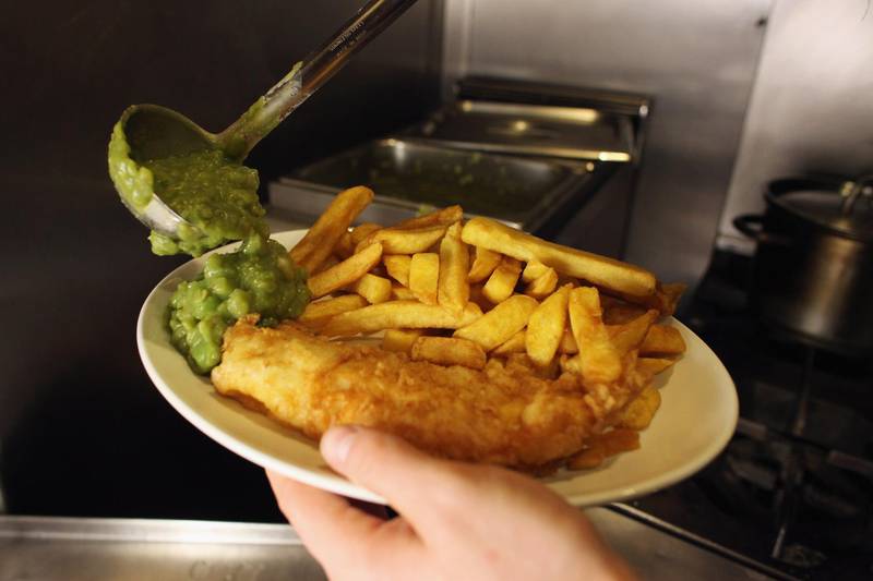 LONDON, ENGLAND - FEBRUARY 22:  A man serves mushy peas on a traditional portion of fish and chips in Olley's fish restaurant on February 22, 2011 in London, England.  (Photo by Oli Scarff/Getty Images)