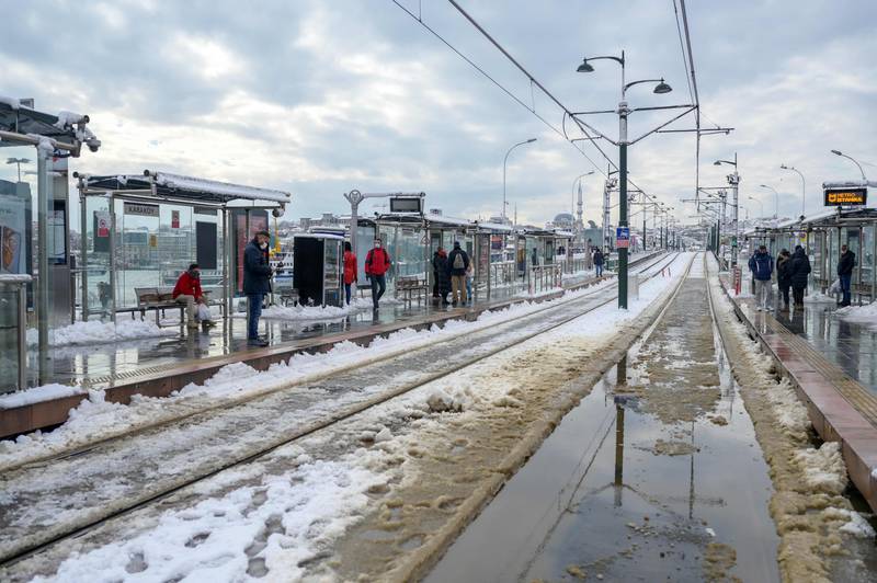Commuters wait for a tram in Istanbul, where roads were blocked and flights and intercity transport cancelled due to snow. AFP