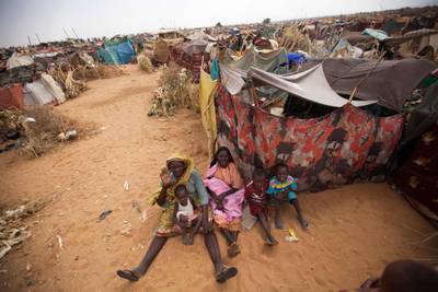 Displaced women and children from Darfur sit outside their shelter in a UN-run camp. AFP