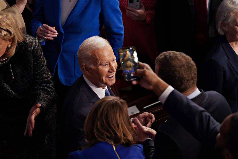 Mr Biden is greeted by members of Congress as he arrives to deliver the address. Bloomberg