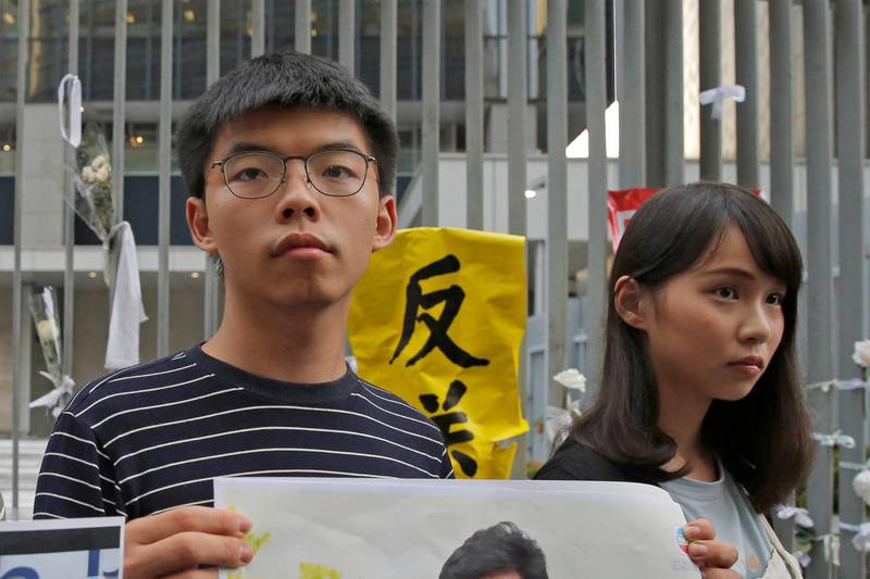 FILE - In this June 18, 2019, file photo, pro-democracy activists Agnes Chow, right, and Joshua Wong speak to the media outside government office in Hong Kong. Demosisto, a pro-democracy group in Hong Kong posted on its social media accounts that well-known activist Joshua Wong had been pushed into a private car around 7:30 a.m. Friday, Aug. 30, 2019 and was taken to police headquarters. It later said another member, Agnes Chow, had been arrested as well. (AP Photo/Kin Cheung, File)