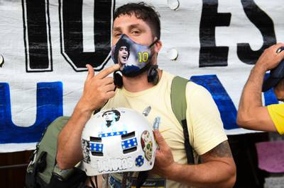 A fan with a Maradona face mask and motorcycle helmet at La Bombonera Stadium in Buenos Aires. Getty