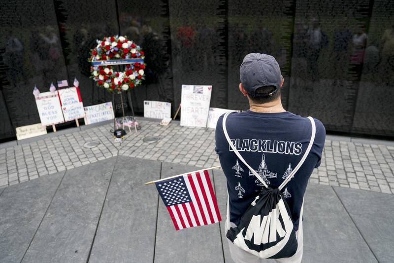 David Romley of Germantown, Md, holds an American flag as he visits the Vietnam Veterans Memorial after Cindy McCain placed a wreath. AP