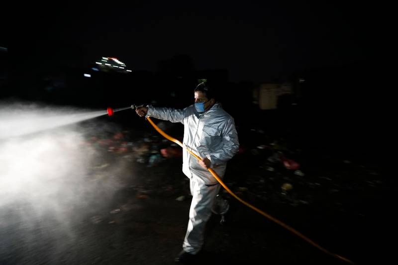 A Yemeni volunteer wearing a protective suit sprays disinfectant at a neighbourhood amid the ongoing Covid-19 pandemic in Sanaa. EPA