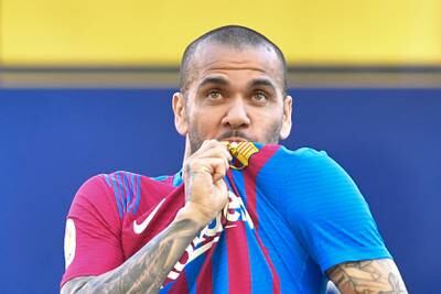 Dani Alves kisses his new jersey during the presentation ceremony. AFP