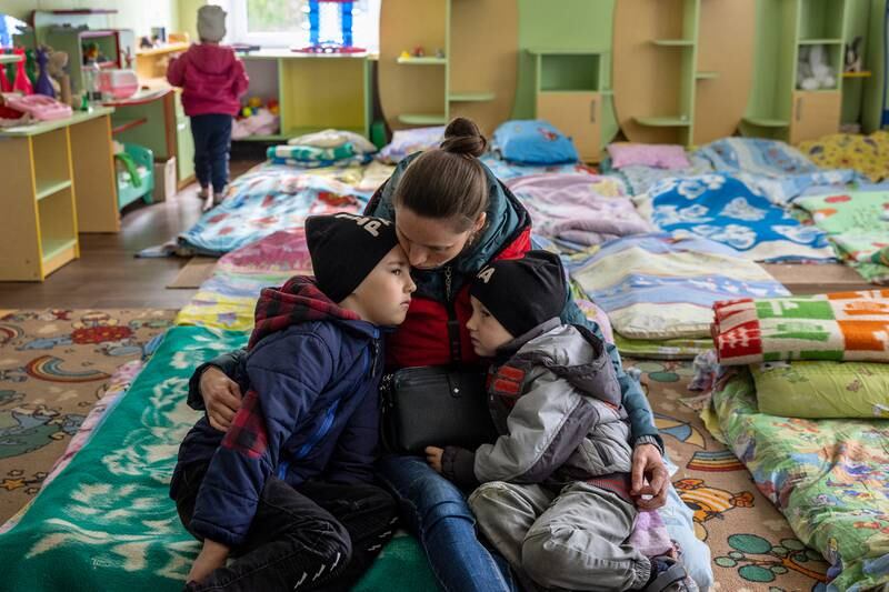 KRYVYI RIH, UKRAINE - MAY 04: Svitlana, 36, holds her sons Artem, 7, and Kyrylo, 5, while taking shelter in a kindergarten on May 04, 2022 in Kryvyi Rih, Ukraine. They had escaped the frontline village of Kyselivka, now under Russian control, in Ukraine's southern Kherson region. Her husband and the boys' father was already working abroad before the war and will meet them in Poland. The Ukrainian city and district of Kryvyi Rih, known as an industrial center and the hometown of President Volodymyr Zelensky, lies less than 70km north of Russian-occupied areas in nearby Kherson Oblast, where invading Russian forces have sought to create a land bridge between the Crimean peninsula and  the eastern Donbas region. (Photo by John Moore / Getty Images)