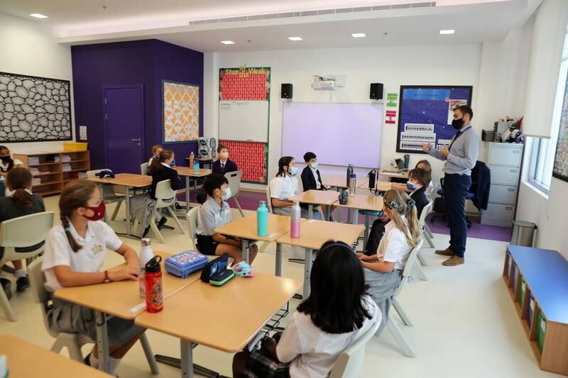 Children listen to teacher Mr Fox, on their first day back at Repton Al Barsha in Dubai.