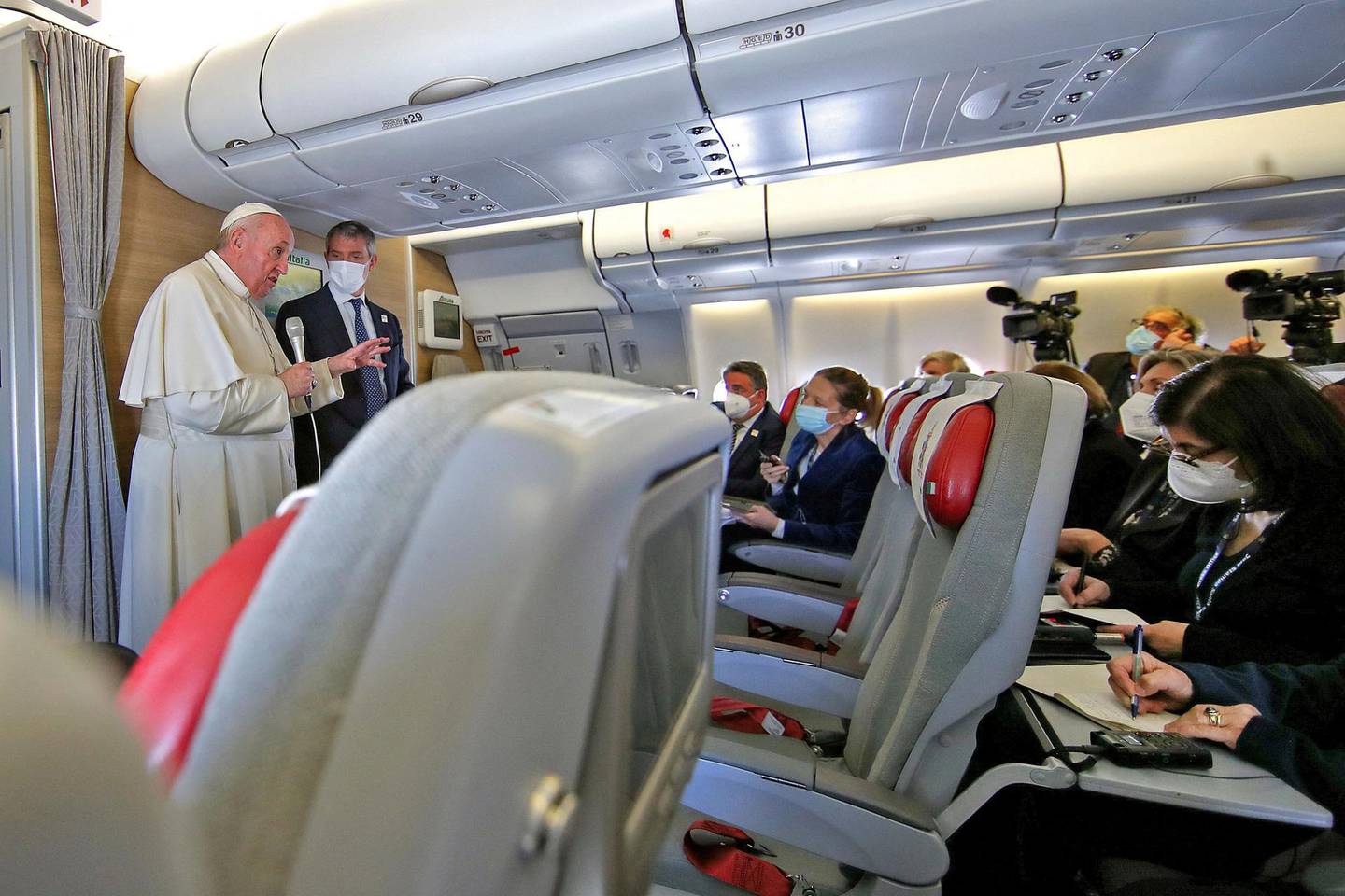Pope Francis speaks to reporters during a news conference while in the air aboard the Alitalia papal plane on his flight back from Iraq, March 8, 2021.   / AFP / POOL / YARA NARDI
