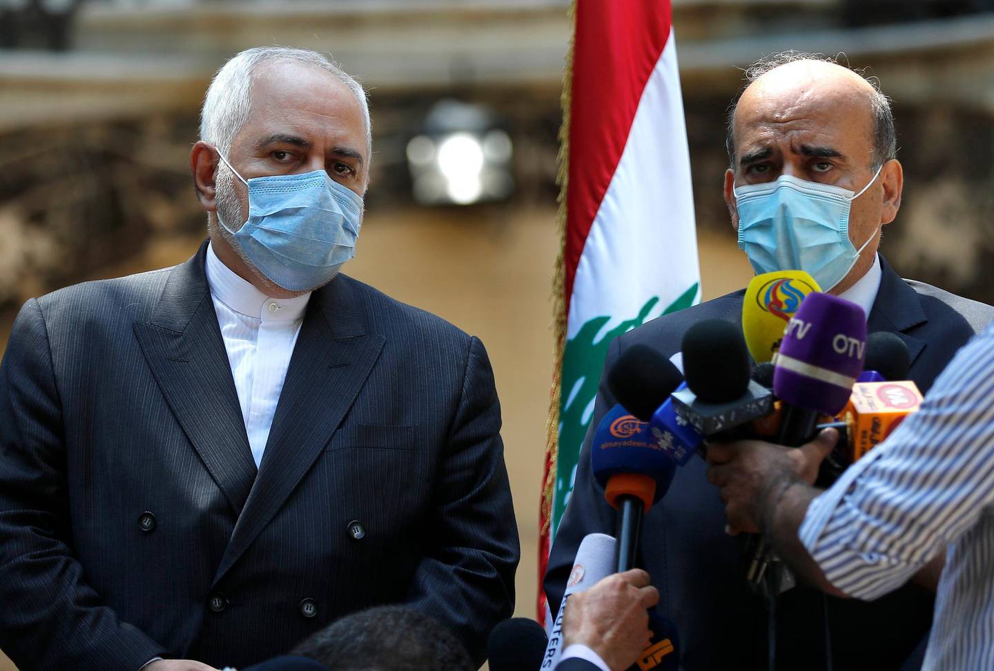 Lebanese Foreign Minister Charbel Wehbe, left, speaks during a joint press conference with his Iranian counterpart Mohammad Javad Zarif, outside the Lebanese foreign ministry damaged by last week's explosion that his the seaport of Beirut, Lebanon, Friday, Aug. 14, 2020. (AP Photo/Hussein Malla)