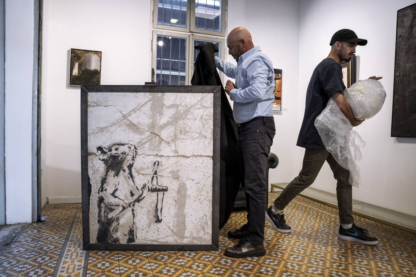 Koby Abergel, an Israeli art dealer, reveals the Banksy piece, which has resurfaced. AP