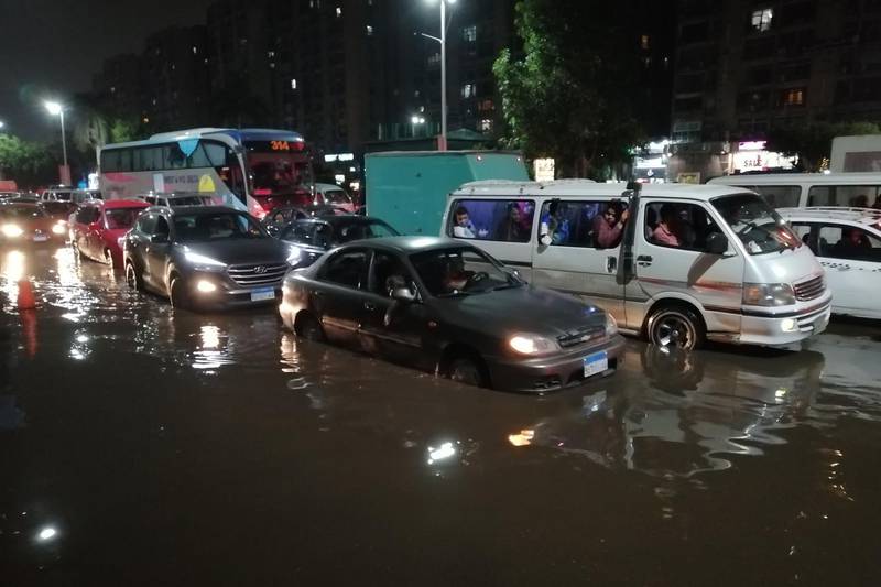 Cars drive on a flooded street following rainfall that led to traffic jam in the Heliopolis district in the Egyptian capital Cairo. AFP