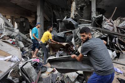 People dig through the rubble of a destroyed building following Israeli strikes on Al Shatee camp in Gaza city. AFP
