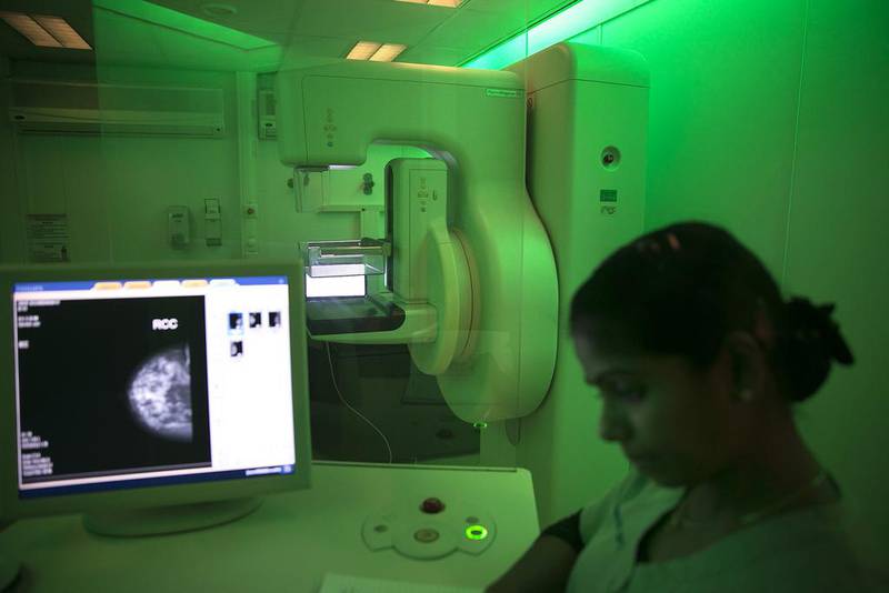A radiology technician checks the computer inside a mobile mammogram clinic (Silvia Razgova / The National)