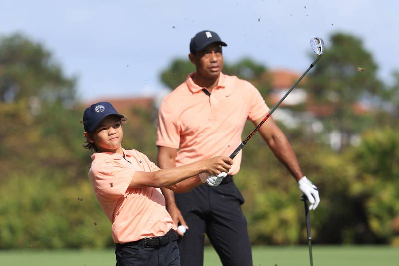 Charlie Woods plays a shot on the second hole as Tiger Woods looks on. AFP