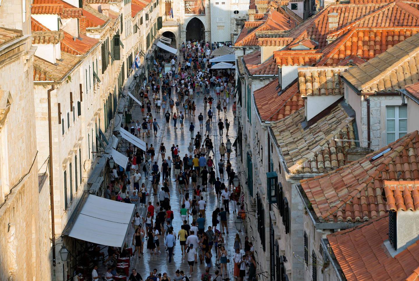 In this Sept. 7, 2018 photo, tourists walk through Dubrovnik old town. Crowds of tourist are clogging the entrances into the ancient walled city, a UNESCO World Heritage Site, as huge cruise ships unload thousands more daily. (AP Photo/Darko Bandic)