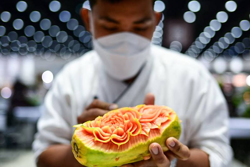 A competitor creates an intricate design on a papaya during a fruit and vegetable carving contest at the 26th Thailand International Culinary Cup in Bangkok. All photos: AFP