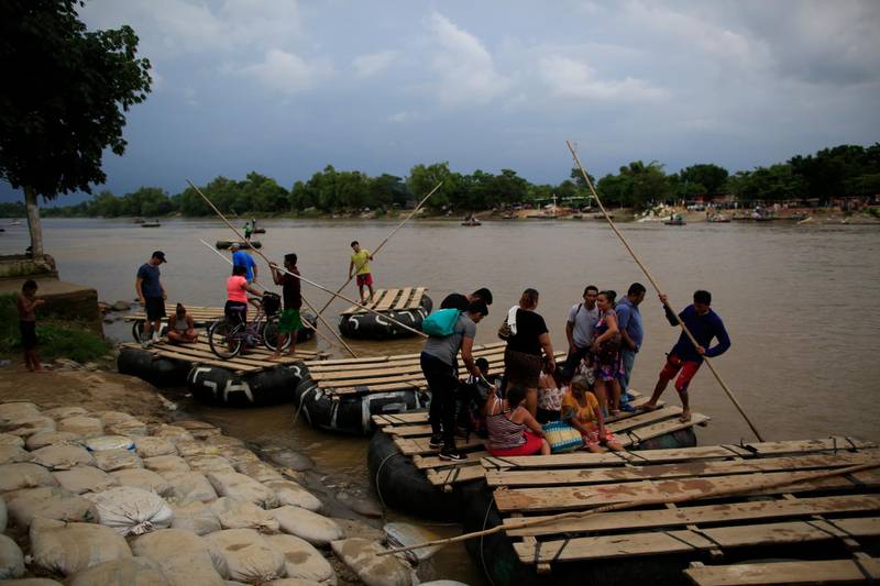 Commuters board rafts to be ferried across the Suchiate River to Guatemala, from Ciudad Hidalgo, Mexico, Wednesday, June 12, 2019. Mexican officials said Tuesday they were beginning deployment of the country's new National Guard for immigration enforcement, but on Wednesday morning, commuters, merchandise, and occasional groups of migrants continued to flow freely across the Suchiate on Mexico's porous southern border. (AP Photo/Rebecca Blackwell)