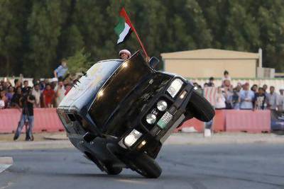 Haran Al Ghufli waves a UAE flag out of a Land Cruiser driven on two wheels by Mohammed Al Matlae at the Fast & Furious 6 "Extreme Car Park" event at Studio City in Dubai. Sarah Dea/The National