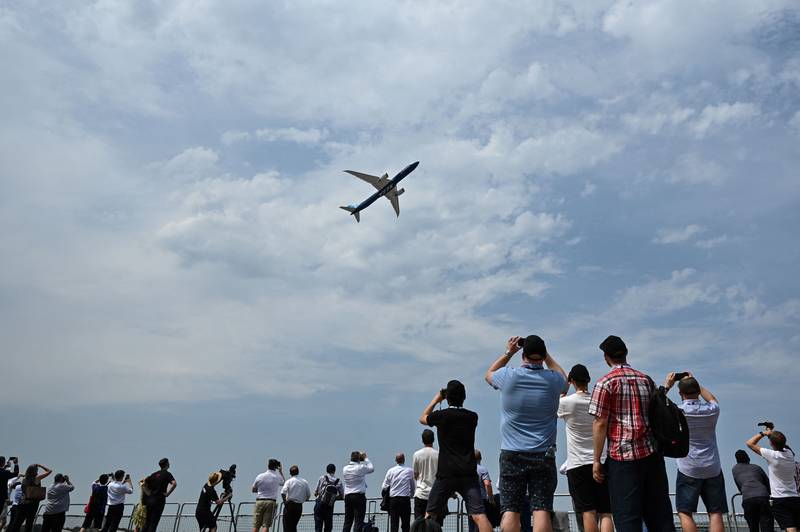 Vistors watch a plane take part in a display at Farnborough International Airshow. The UK government on Tuesday launched its Jet Zero strategy at the event. AFP