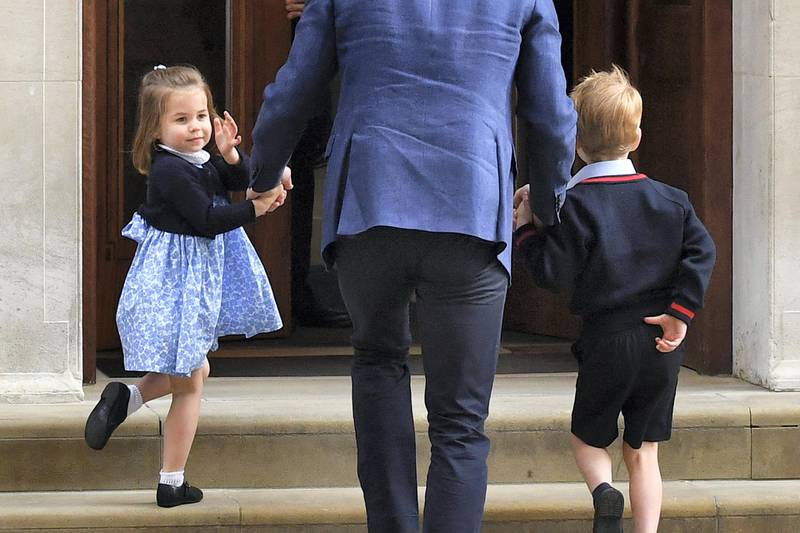 Princess Charlotte of Cambridge (L) turns to wave at the media as she is lead in with her brother Prince George of Cambridge (R) by their father Britain's Prince William, Duke of Cambridge, (C) at the Lindo Wing of St Mary's Hospital in central London, on April 23, 2018, to visit Catherine, Duchess of Cambridge, and their new-born son. - Kate, the wife of Britain's Prince William, has given birth to a baby son, Kensington Palace announced Monday. "Her Royal Highness The Duchess of Cambridge was safely delivered of a son at 11:01 (1001 GMT)," the palace said in a statement. The baby boy weighs eight pounds and seven ounces (3.8 kilogrammes). (Photo by Ben STANSALL / AFP)