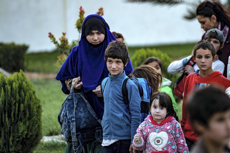 Russian children and an adolescent woman from the Kurdish-run al-Hol camp, which holds displaced families accused of being related to the Islamic State (IS) group, are handed over to a delegation from their country, in the northeastern Syrian city of Qamishli, on November 12, 2020. - A Kurdish foreign affairs official told AFP that 30 children and teenage girls between the ages of 2 and 14 were handed over to the Russian delegation. (Photo by Delil SOULEIMAN / AFP)