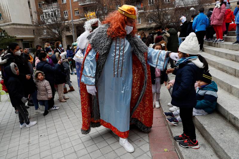 Children react as men wearing masks dressed as the Three Wise Men arrive to greet them while they wait to receive toys given out to low-income families by the NGO Madrina Foundation before Epiphany in Madrid, Spain. Reuters