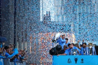 Manchester City players carry the Uefa Champions League trophy, the FA Cup trophy and the Premier League trophy during the Treble Parade in Manchester in June. PA Wire