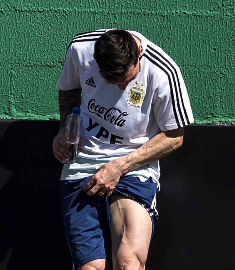Argentina captain Lionel Messi examines his left leg on the sidelines of a training session EPA