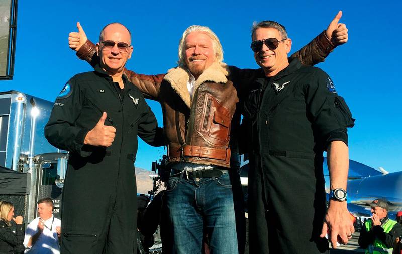 Richard Branson celebrates with pilots Rick “CJ” Sturckow, left, and Mark “Forger” Stucky, right, after Virgin Galactic’s tourism spaceship climbed more than 50 miles high. AP
