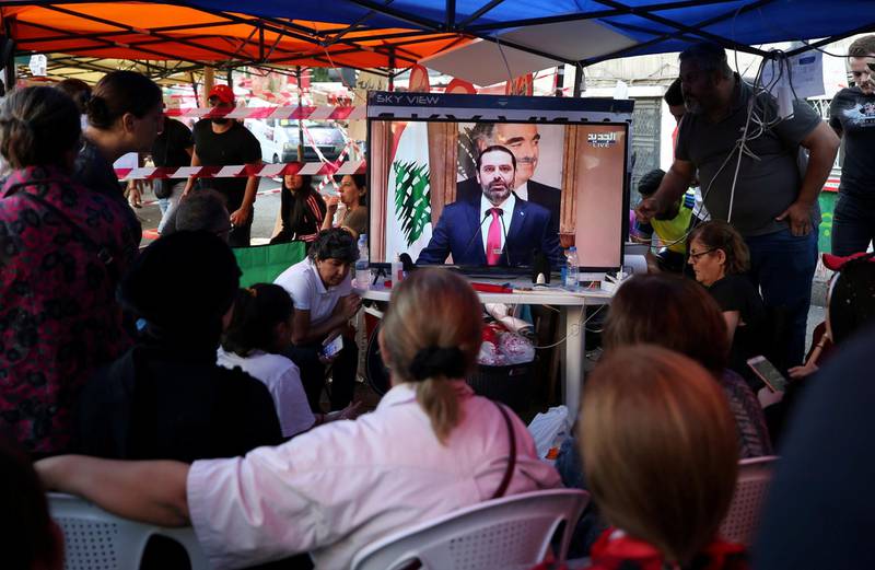 Protestors watch a television broadcast of Lebanon's Prime Minister Saad al-Hariri speaking, in Sidon, Lebanon October 29, 2019. REUTERS/Ali Hashisho     TPX IMAGES OF THE DAY
