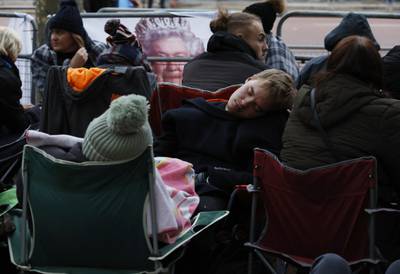 Mourners take a moment to rest on The Mall in London. Reuters