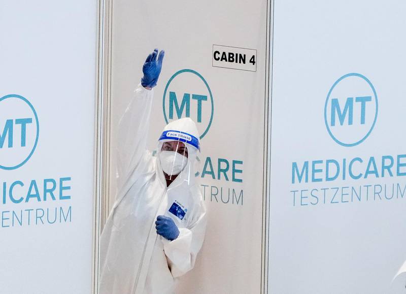 A medical staff member gestures in front of a coronavirus test station at Terminal 1 of the Berlin Brandenburg Airport, Germany. EPA