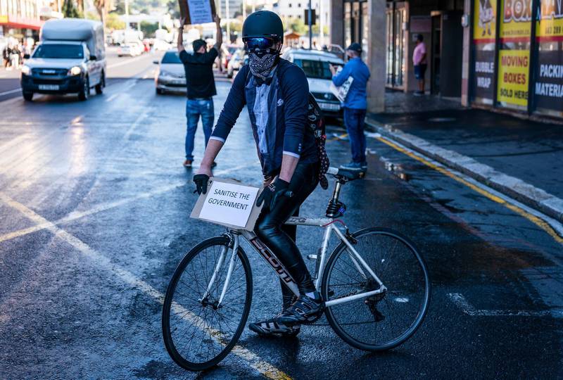 A man uses his bicycle during a protest of hospitality workers against coronavirus lockdown regulations in the streets around Parliament in Cape Town, South Africa, 24 July 2020.  EPA