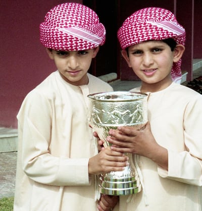 In this childhood photo, Sheikh Hamdan and his brother, Sheikh Maktoum bin Mohammed, hold a camel racing trophy. 