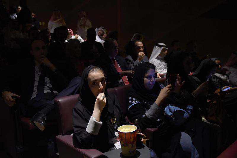A Saudi woman eats popcorn at the AMC cinema during a test screening in Riyadh on April 18, 2018.
Blockbuster action flick "Black Panther" play at a cinema test screening in Saudi Arabia on April 18, the first in a series of trial runs before movie theatres open to the wider public next month. The conservative kingdom lifted a 35-year ban on cinemas last year as part of a far-reaching liberalisation drive, with US giant AMC Entertainment granted the first licence to operate movie theatres. / AFP PHOTO / Fayez Nureldine