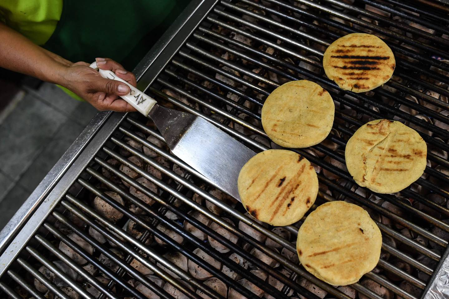 A man prepares arepas, made from maize, the most popular and traditional food in Venezuela, at a restaurant in Caracas, on October 28, 2021. AFP