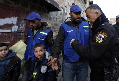 epa07357774 An Israeli policeman argues with one of the Palestinians wearing blue vests marking them as 'Oservers' during a protest against the end of the mandate for the civilian Temporary International Presence in Hebron (TIPH) in the West Bank city of Hebron, 10 February 2019. The protest was aimed at marking the removal of the international observers mission from Hebron and anniversary of the so-called Cave of the Patriarchs massacre by Israeli settler Baruch Goldstein on 25 February 1994, that initially led to the establishing of the TIPH.  EPA/ABED AL HASHLAMOUN