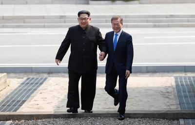 South Korean president Moon Jae-in, right, returns after briefly stepping into North Korea. Korea Summit Press Pool via AP