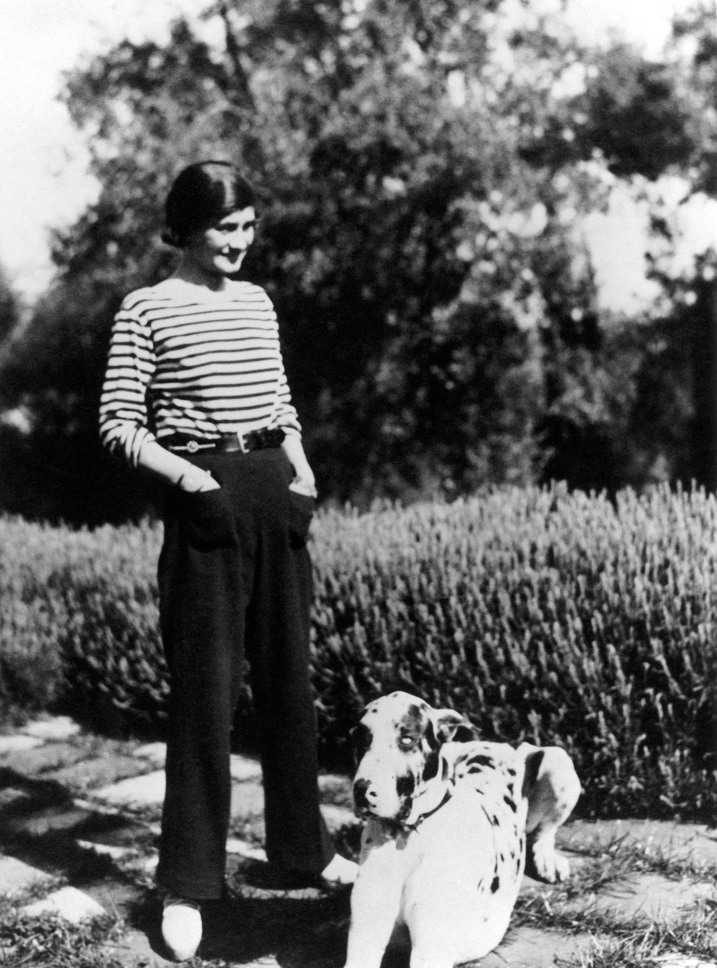 Gabrielle Chanel wearing a pair of trousers, with her dog Gigot at Villa La Pausa in Roquebrune, France, circa 1930. Photo: Granger / Shutterstock 