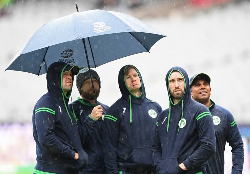 Members of the Ireland team watch the rain fall before their match against Afghanistan was abandoned. Getty Images