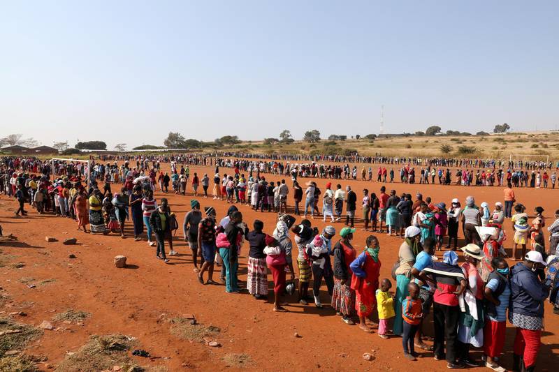 People stand in a queue to receive food aid amid the spread of the coronavirus disease (COVID-19), at the Itireleng informal settlement, near Laudium suburb in Pretoria, South Africa, May 20, 2020. REUTERS