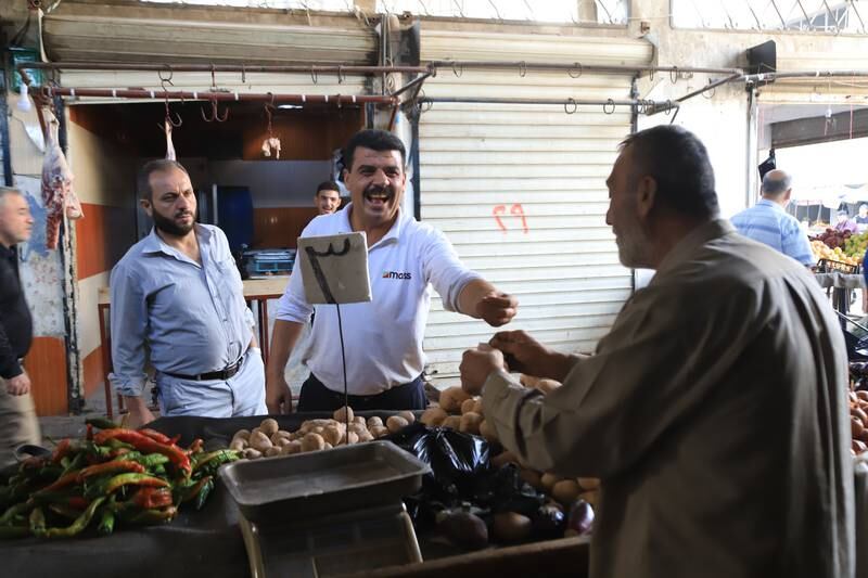 A 60-year-old man sells vegetables to a customer. Abd Almajed Alkarh for The National