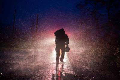 Montegut fire chief Toby Henry walks back to his fire truck in the rain. AFP