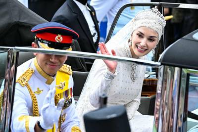 Prince Abdul Mateen and Yang Mulia Anisha Rosnah wave to the crowds. AFP 