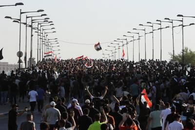 Mr Al Sadr's supporters walk across a bridge to the Green Zone during a protest against corruption in Baghdad. Reuters
