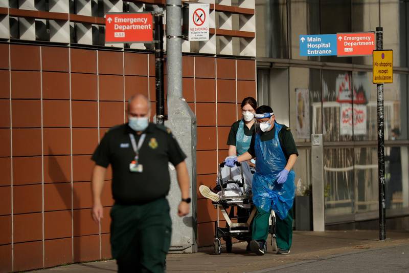 A patient is wheeled on a trolley after arriving in an ambulance outside the Royal London Hospital in east London. AP Photo