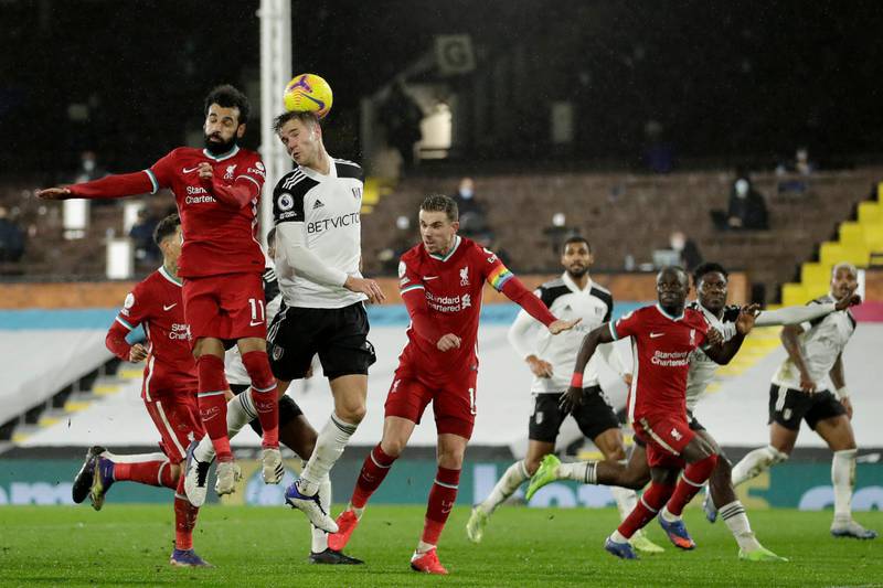 Liverpool's Mohamed Salah, left, jumps for the ball against Fulham. AP