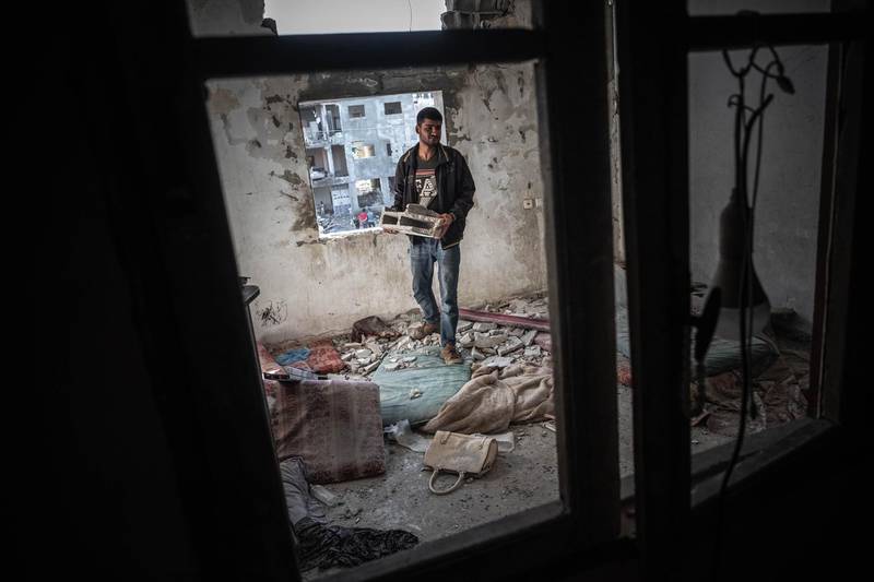 A Palestinian man tries to put his home back in order after Israeli air strikes on Beit Hanoun, Gaza. Getty